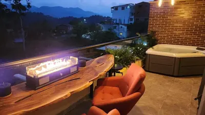 a balcony with a table and chairs and a hot tub at San Telmo Guatape Apto con Jacuzzy in Guatapé