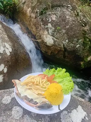 a plate of food on a table next to a waterfall at Casa de piedra #35 in San Rafael