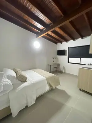 a white bedroom with a bed and a table at Living Yellow in Alpujarra
