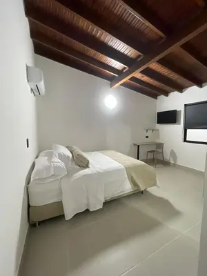 a white bedroom with a bed and a television at Living Yellow in Alpujarra