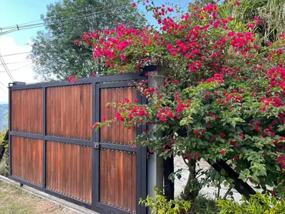 a wooden fence with pink flowers on it at Kamalú Glamping in Medellín