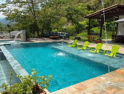 a swimming pool with green chairs and a swimming pool at Finca en Sopetran con Piscina lnfinita y Jacuzzi in Sopetran