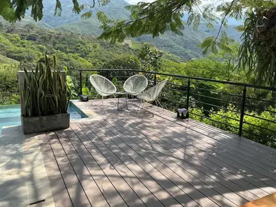 a deck with two chairs and a view of the mountains at Finca en Sopetran con Piscina lnfinita y Jacuzzi in Sopetran