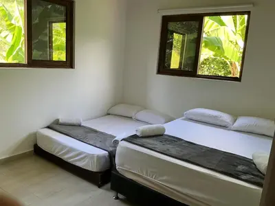 two beds in a room with two windows at Finca en Sopetran con Piscina lnfinita y Jacuzzi in Sopetran