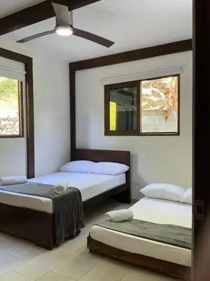 a bedroom with two beds and two windows at Finca en Sopetran con Piscina lnfinita y Jacuzzi in Sopetran