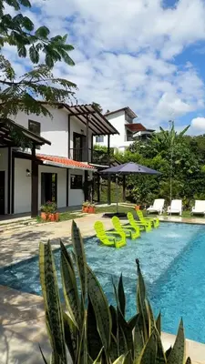 a resort with a swimming pool with yellow lounge chairs at Finca en Sopetran con Piscina lnfinita y Jacuzzi in Sopetran