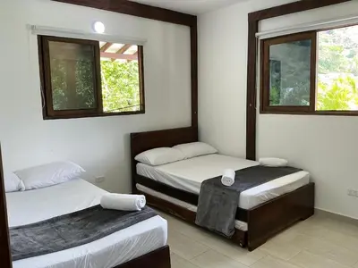 two twin beds in a room with two windows at Finca en Sopetran con Piscina lnfinita y Jacuzzi in Sopetran