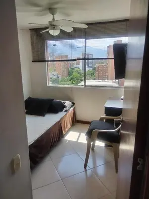 a bedroom with a bed and a window and a desk at Habitación en el poblado in Medellín