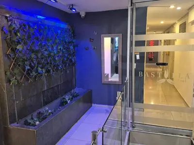 a bathroom with a glass shower and blue walls at Hotel bastilla real in Medellín