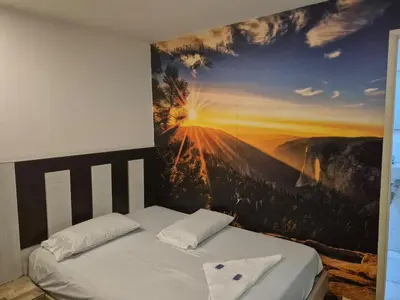 a bedroom with a painting on the wall at Hotel bastilla real in Medellín