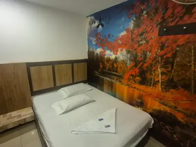 a bed in a room with a painting on the wall at Hotel bastilla real in Medellín