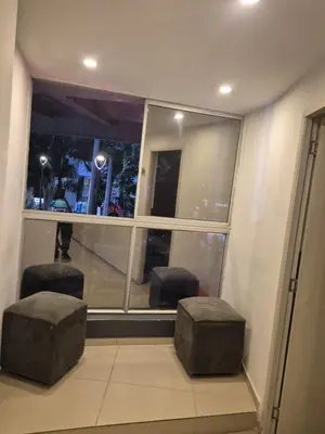 two stools in front of a window in a building at Hotel bastilla real in Medellín