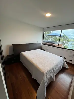 a bedroom with a bed and a large window at Cabaña en Guatapé in Guatapé