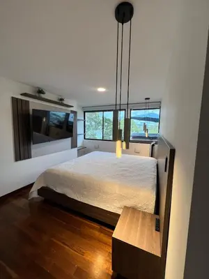 a bedroom with a bed and a bench in it at Cabaña en Guatapé in Guatapé