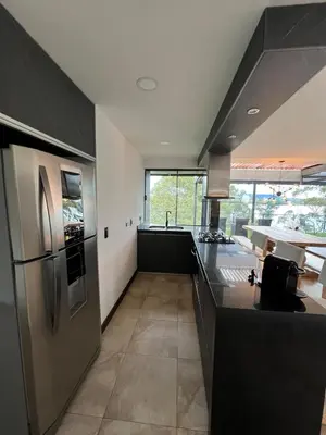 a kitchen with black cabinets and a stainless steel refrigerator at Cabaña en Guatapé in Guatapé