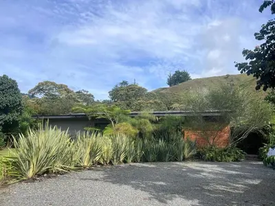 a house with a lot of plants in the yard at Beautiful house in nature minutes from Medellín in El Retiro