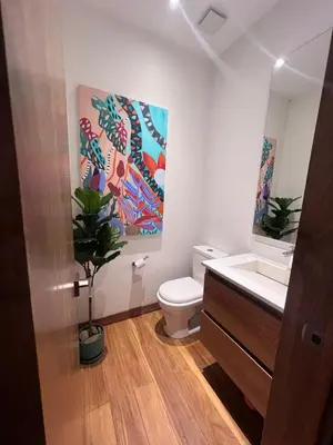 a bathroom with a toilet and a painting on the wall at Beautiful house in nature minutes from Medellín in El Retiro