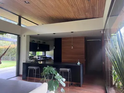 a kitchen with a black counter and stools at Beautiful house in nature minutes from Medellín in El Retiro