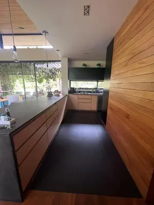 a kitchen with a counter and a wooden wall at Beautiful house in nature minutes from Medellín in El Retiro