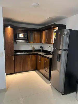 a kitchen with wooden cabinets and a stainless steel refrigerator at Spacious and bright in Medellín