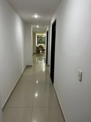 a hallway with white walls and a white tile floor at Spacious and bright in Medellín