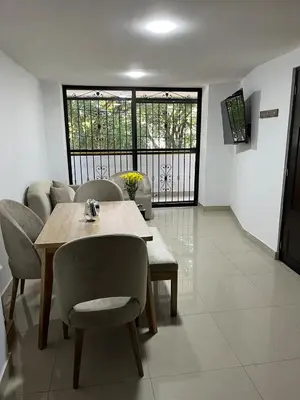 a living room with a table and chairs and a couch at Spacious and bright in Medellín