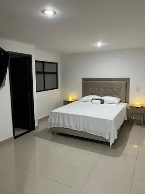 a bedroom with a large bed and two lamps at Spacious and bright in Medellín