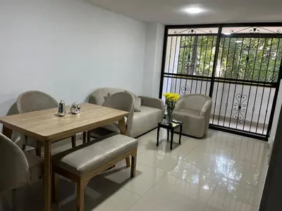 a dining room with a table and chairs and a couch at Spacious and bright in Medellín