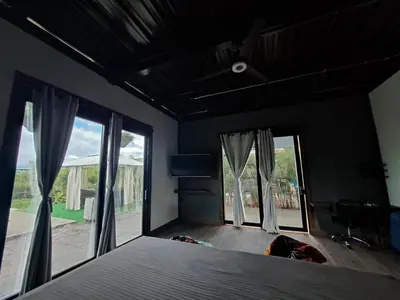 a bedroom with a bed and two large windows at Hotel Elixer Habitat in Santa Rosa de Cabal