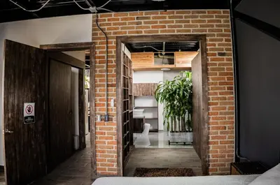 a brick hallway leading to a room with a plant at Hotel Elixer Habitat in Santa Rosa de Cabal