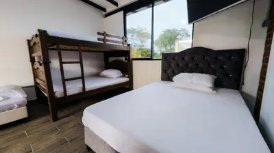 a bedroom with two bunk beds and a white bed at Hotel Elixer Habitat in Santa Rosa de Cabal