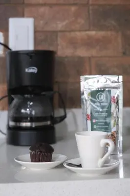 a cup of coffee and a cupcake on a counter at Hotel Elixer Habitat in Santa Rosa de Cabal
