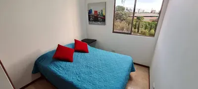 a bedroom with a blue bed with two red pillows at Balsos de oviedo in Medellín