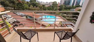 a balcony with chairs and a swimming pool at Balsos de oviedo in Medellín