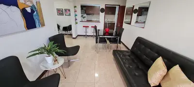 a living room with a black couch and chairs at Balsos de oviedo in Medellín