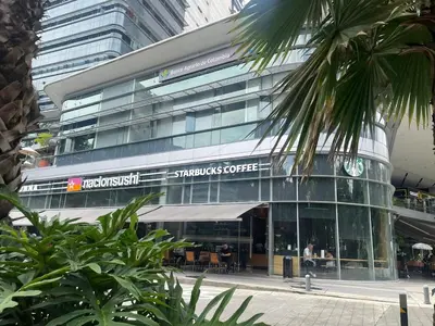 a tall glass building with a restaurant in front of it at Studio apartment in El Poblado next to Oviedo Mall in Medellín