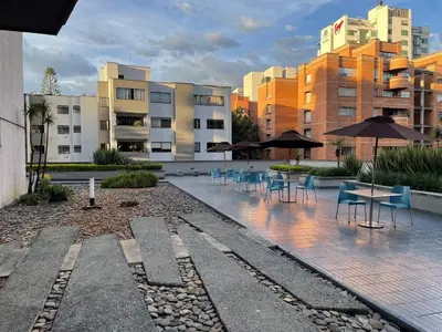 a courtyard with chairs and tables and umbrellas at Studio apartment in El Poblado next to Oviedo Mall in Medellín