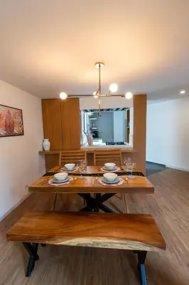 a dining room with a wooden table with glasses on it at Duplex First laureles park in Medellín