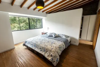 a bedroom with a bed and a large window at Duplex First laureles park in Medellín