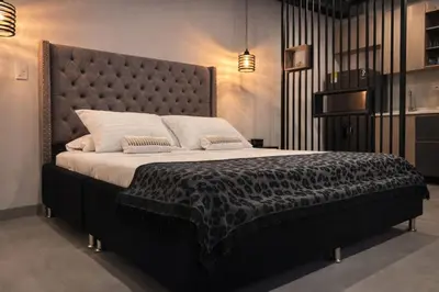 a bedroom with a large bed with a large headboard at Loft de lujo en Laureles in Medellín