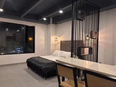 a bedroom with a bed and a table and a window at Loft de lujo en Laureles in Medellín