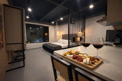 a room with a table with a tray of food and wine glasses at Loft de lujo en Laureles in Medellín