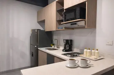 a kitchen with a counter top with two cups and a refrigerator at Loft de lujo en Laureles in Medellín