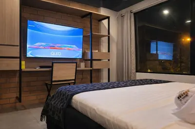 a hotel room with a bed and a tv at Loft de lujo en Laureles in Medellín