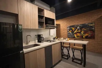 a kitchen with a sink and a counter with a stove at Loft de lujo en Laureles in Medellín