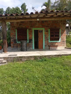 a brick house with a table and chairs in a yard at La Luna cabin in Amagá