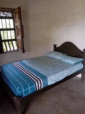 a small bed in a room with a window at La Luna cabin in Amagá