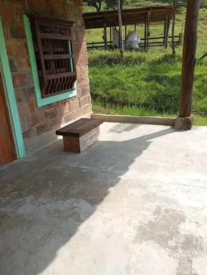 a bench sitting in front of a brick building at La Luna cabin in Amagá