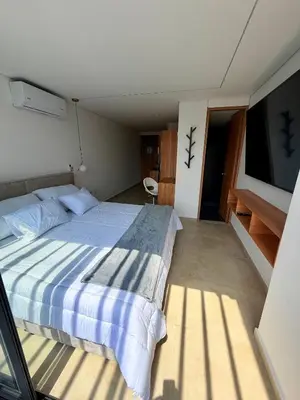 a bedroom with a large bed and a flat screen tv at Lujoso y cómodo Loft en Laureles in Medellín