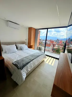 a bedroom with a large bed and a large window at Lujoso y cómodo Loft en Laureles in Medellín
